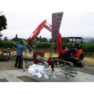 installing windmill with backhoe